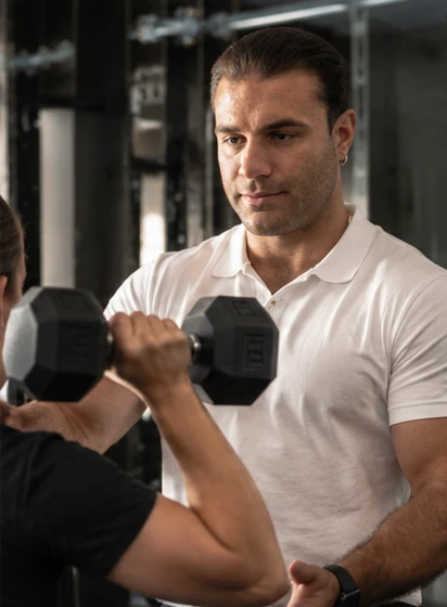 André Reinl begleitet eine Klientin beim Training mit der Kurzhantel